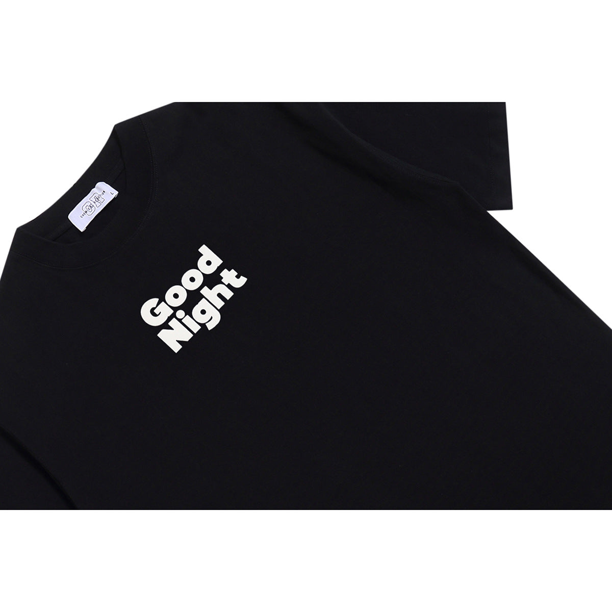 Close-up of a black T-shirt with white “Good Night” lettering on the chest and a visible neck label.