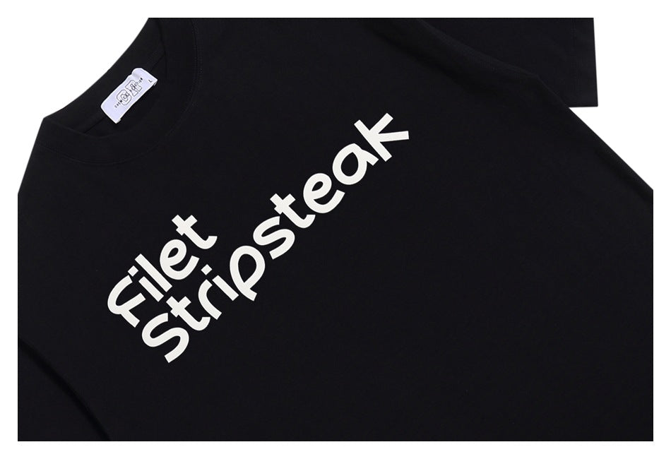 Close-up of a black T-shirt with large white “Filet Stripsteak” lettering across the front.