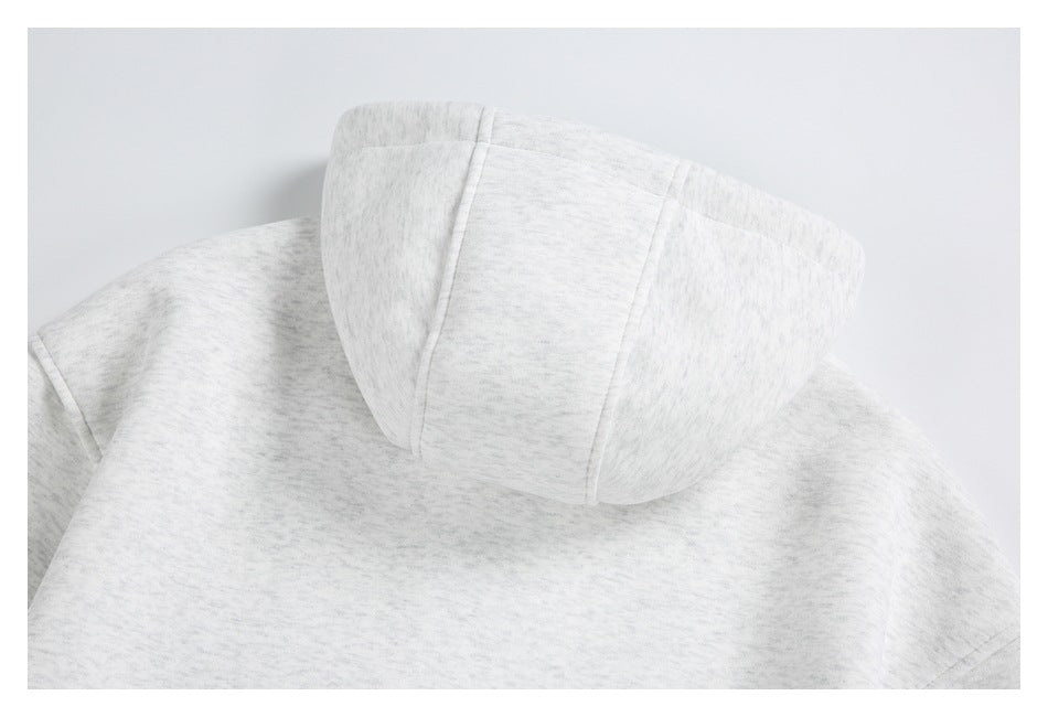 Close-up of the back and panel-seamed hood of a light heather gray sweatshirt.