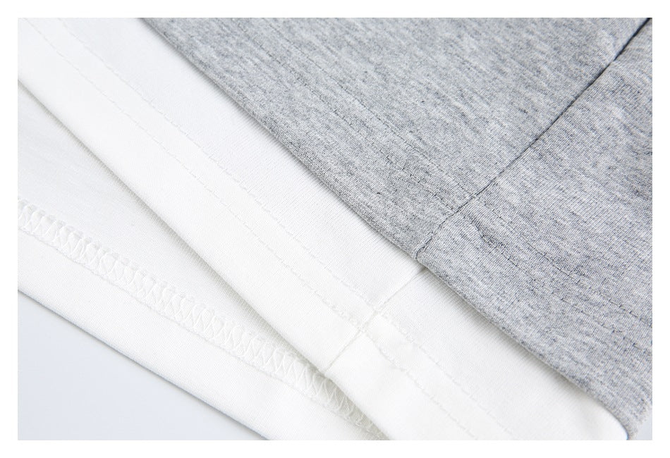 Close-up of the heather-gray garment hem and white underside, showing seams and overlock stitching.