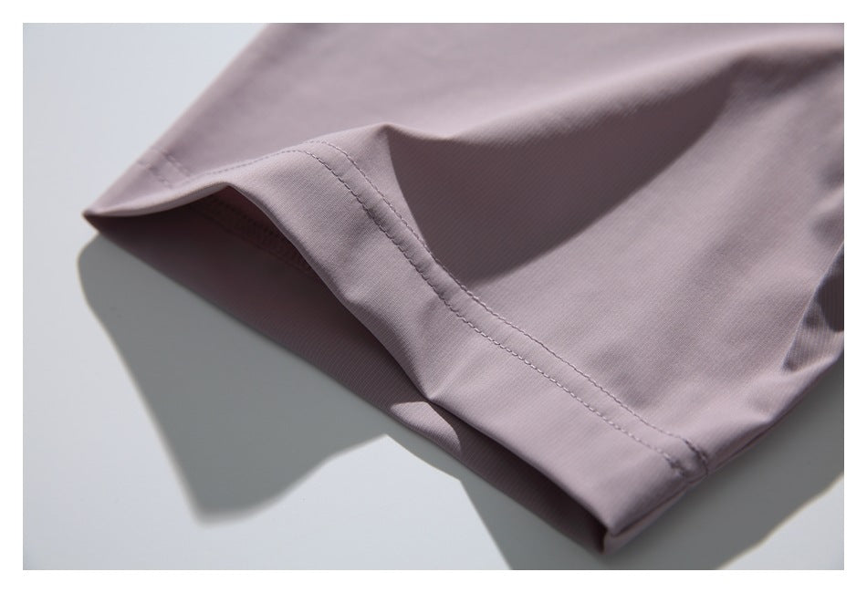 Close-up of a stitched hem on dusty mauve shirt fabric.