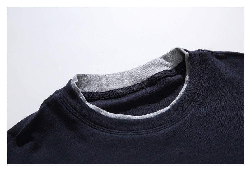 Close-up of a dark navy T-shirt crew neckline with a light gray inner collar and contrast edging.