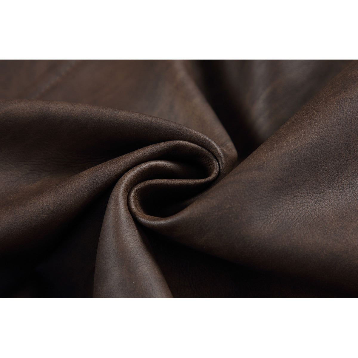 Macro view of dark brown jacket material folded to show its fine, pebbled surface.