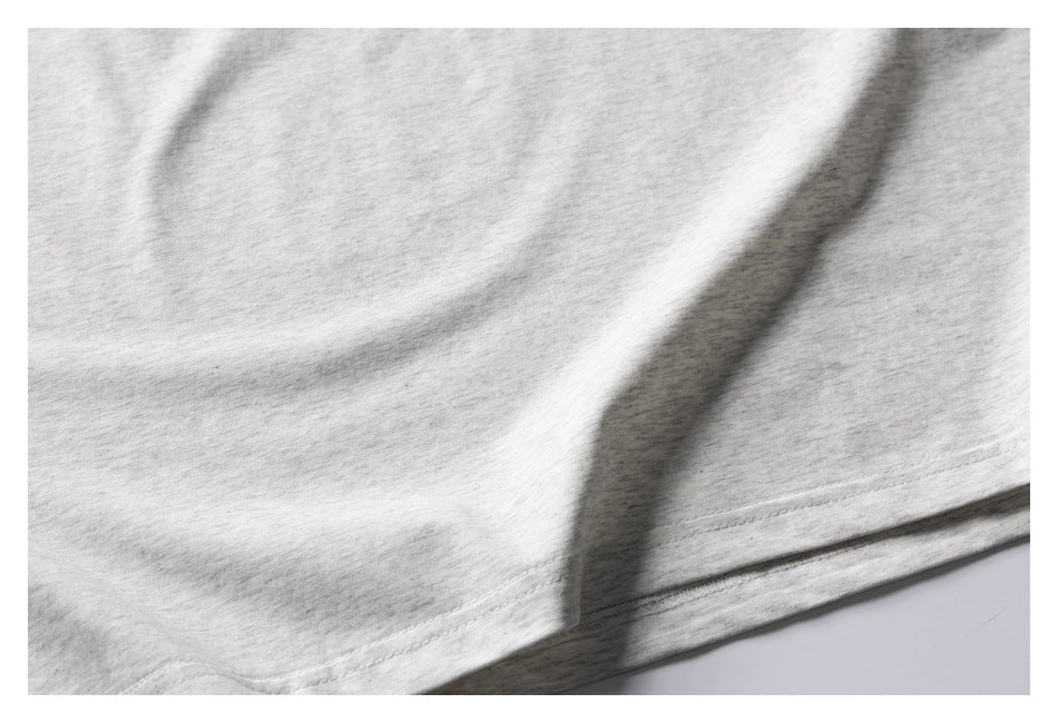 Close-up of light gray heathered fabric with a double-stitched hem.