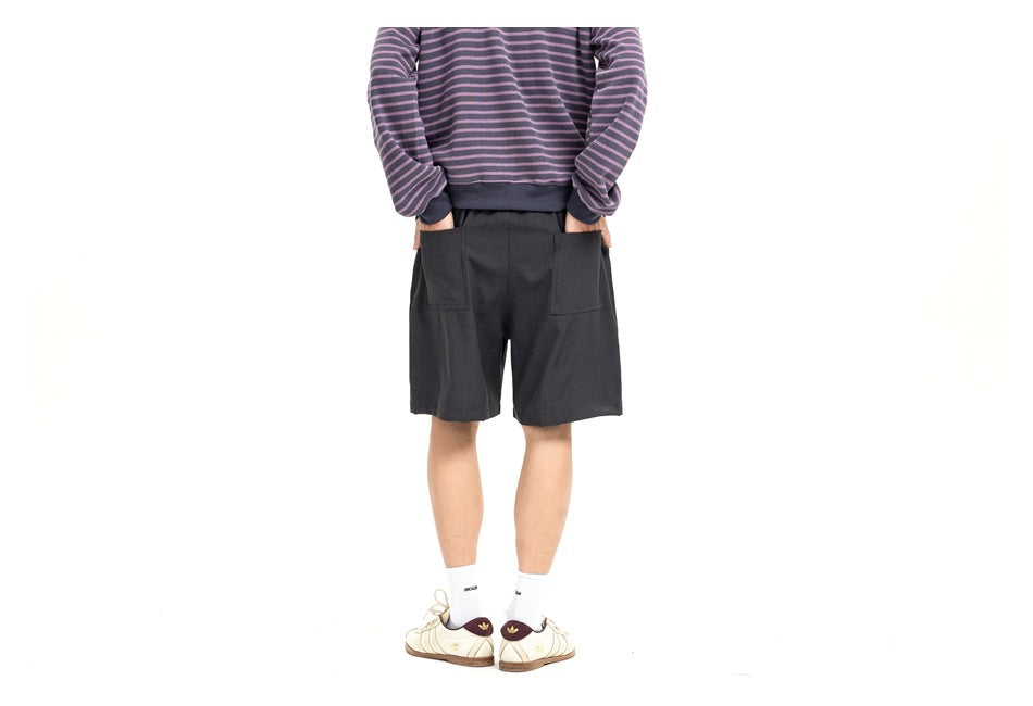 Cropped model wearing charcoal shorts with front pockets and a purple-and-gray striped sweatshirt.