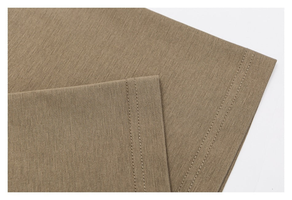 Close-up of a taupe garment edge with parallel rows of stitching.