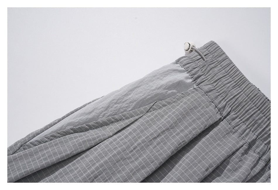 Close-up of the gathered waistband and layered gray panels with a subtle grid pattern.