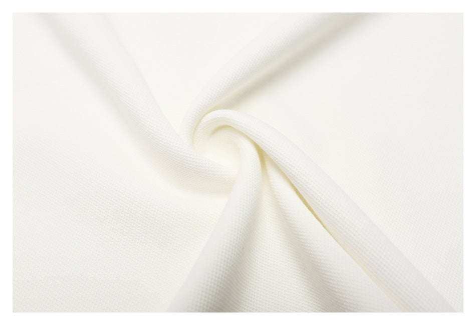 Close-up of off-white textured polo fabric gathered into a soft twist.