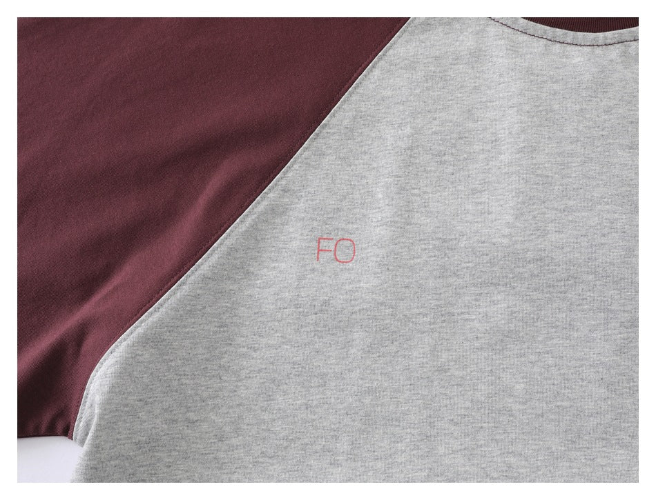 Close-up of the gray shirt front and burgundy sleeve, showing small red “FO” lettering.