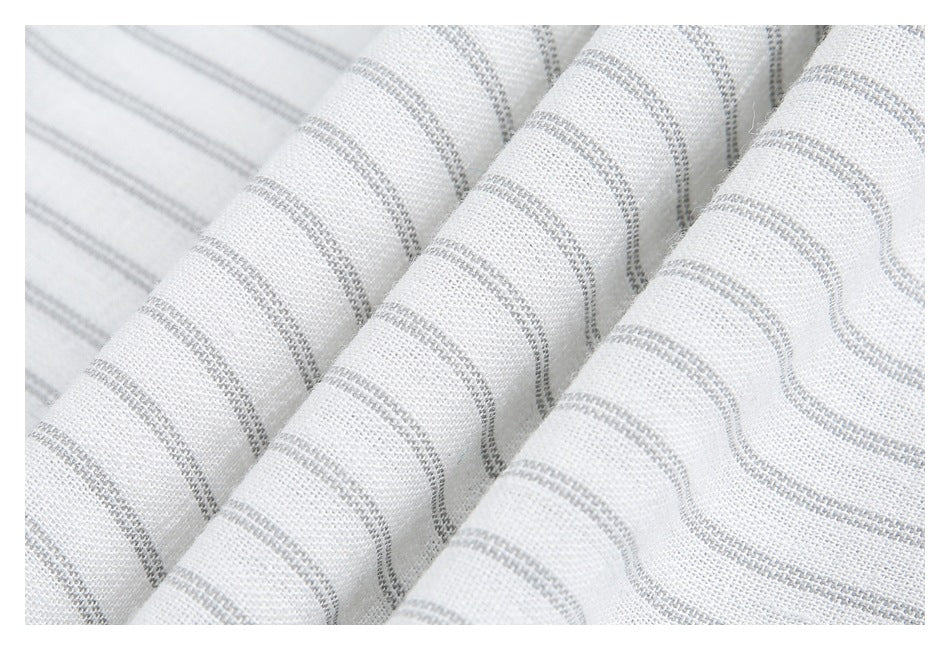 Close-up of white fabric with fine gray stripes gathered into soft folds.