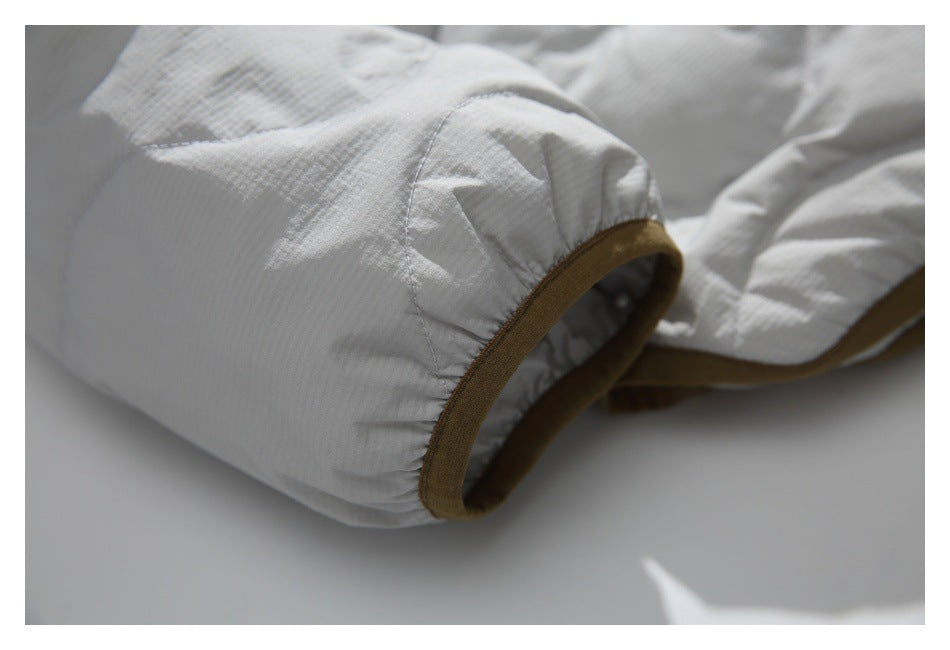Close-up of the jacket's gathered sleeve cuff with brown binding.