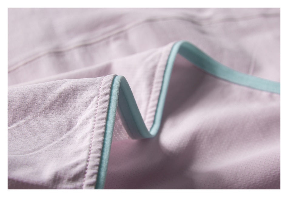 Close-up showing pale pink garment edges finished with mint-green piping.