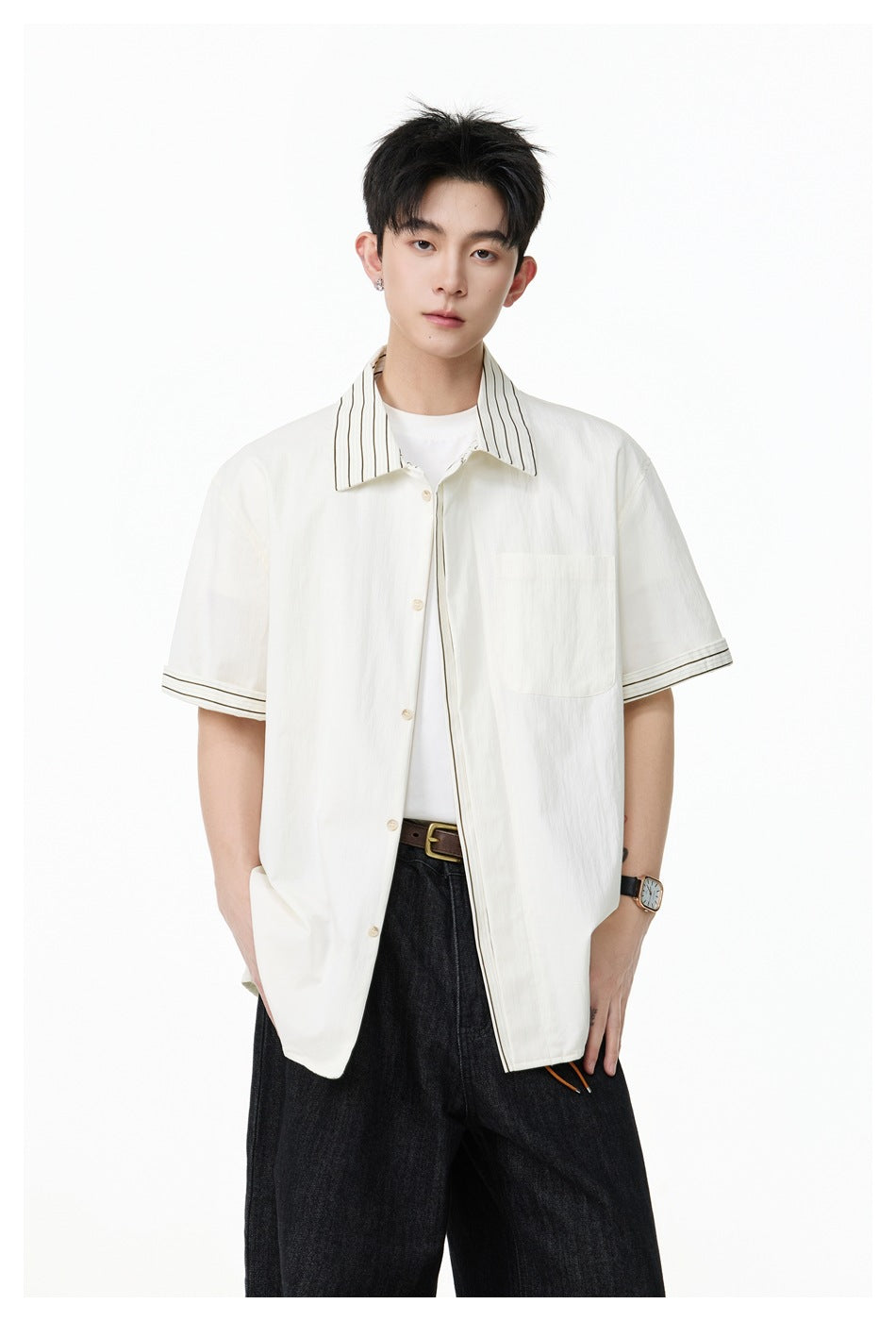 Closer view of a model wearing an ivory short-sleeve button-up shirt with striped collar and cuffs and a chest pocket.