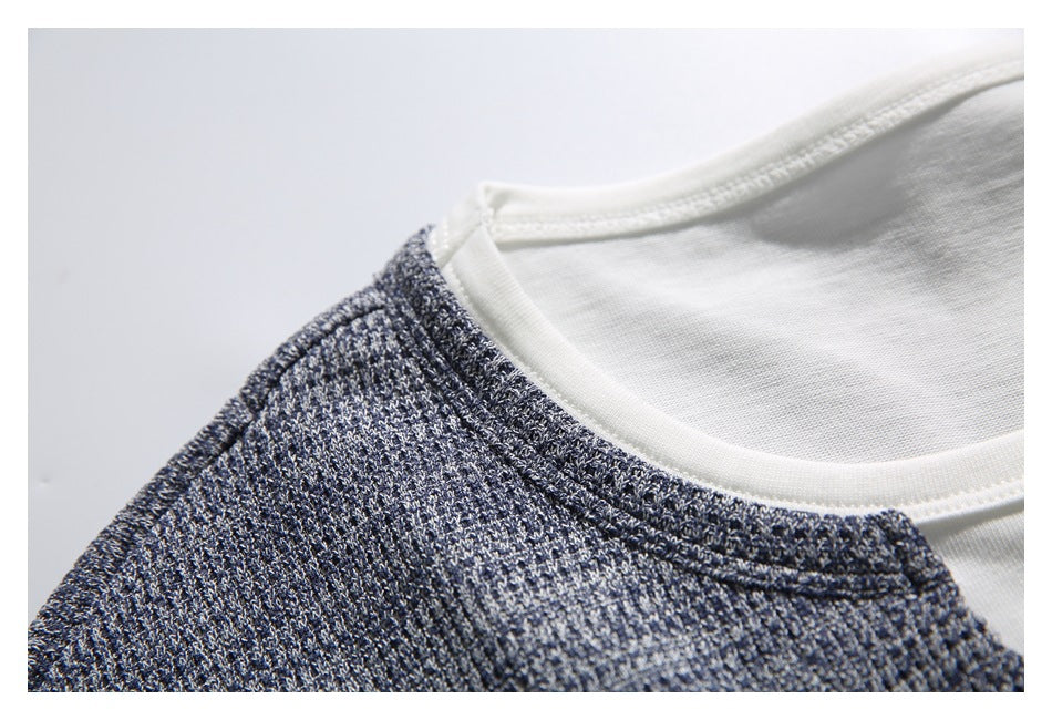 Close-up of the white crew neckline and gray-blue textured fabric at the shoulder.