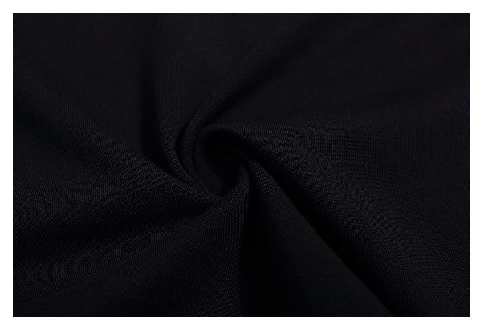 Close-up of black fabric gathered into folds, showing its fine surface texture.