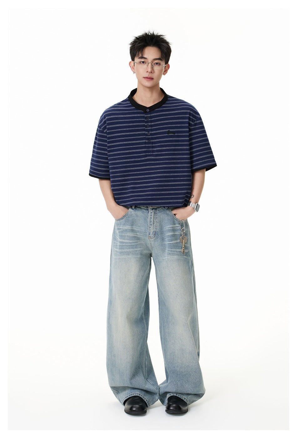 Model wearing the navy striped Henley T-shirt with hands in the pockets of wide-leg light-wash jeans