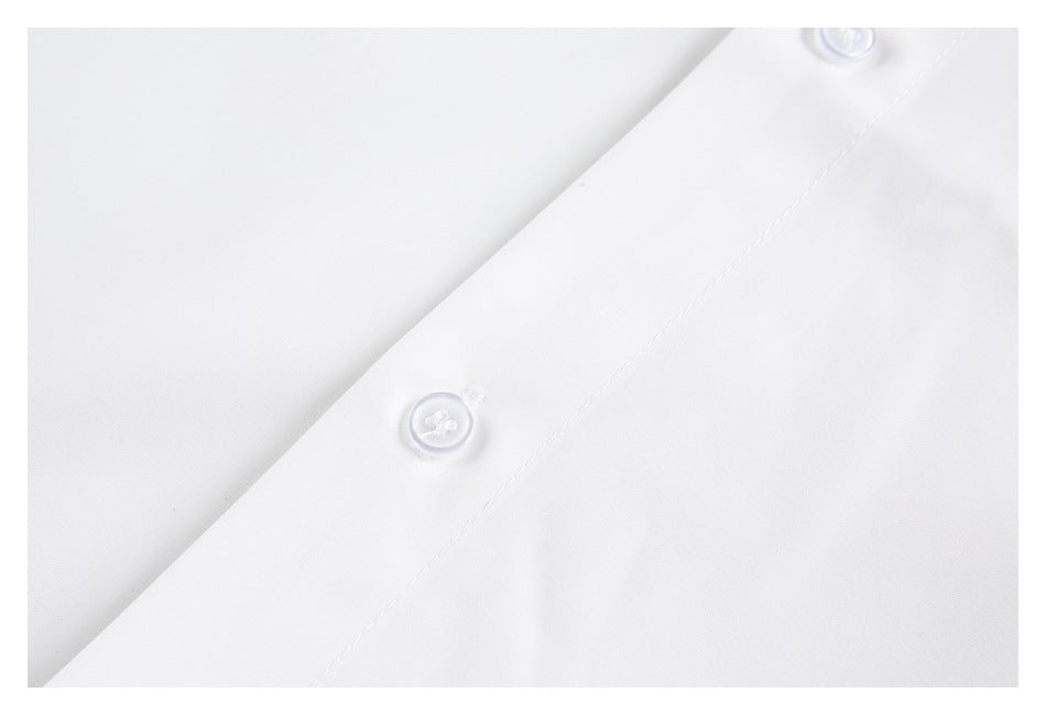 Close-up of white buttons and stitching along a white shirt placket.