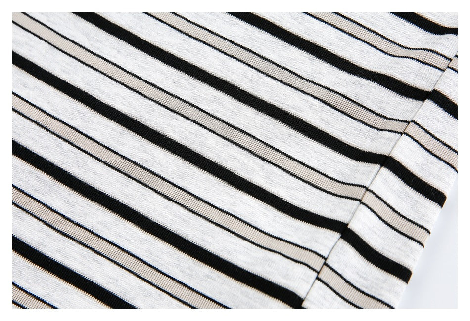 Close-up of black stripes across the white shirt body and a side seam.