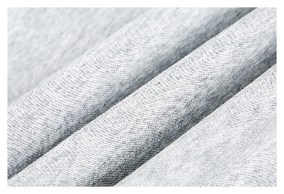 Close-up of light gray heathered knit fabric arranged in soft folds.