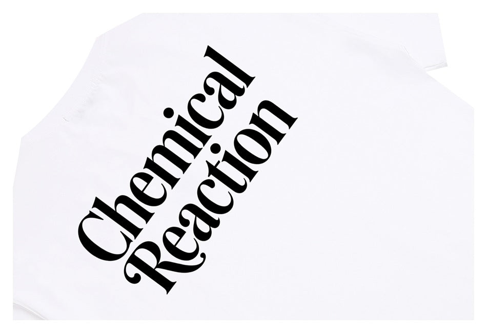 Close-up of a white T-shirt with large black “Chemical Reaction” lettering printed diagonally across the front.