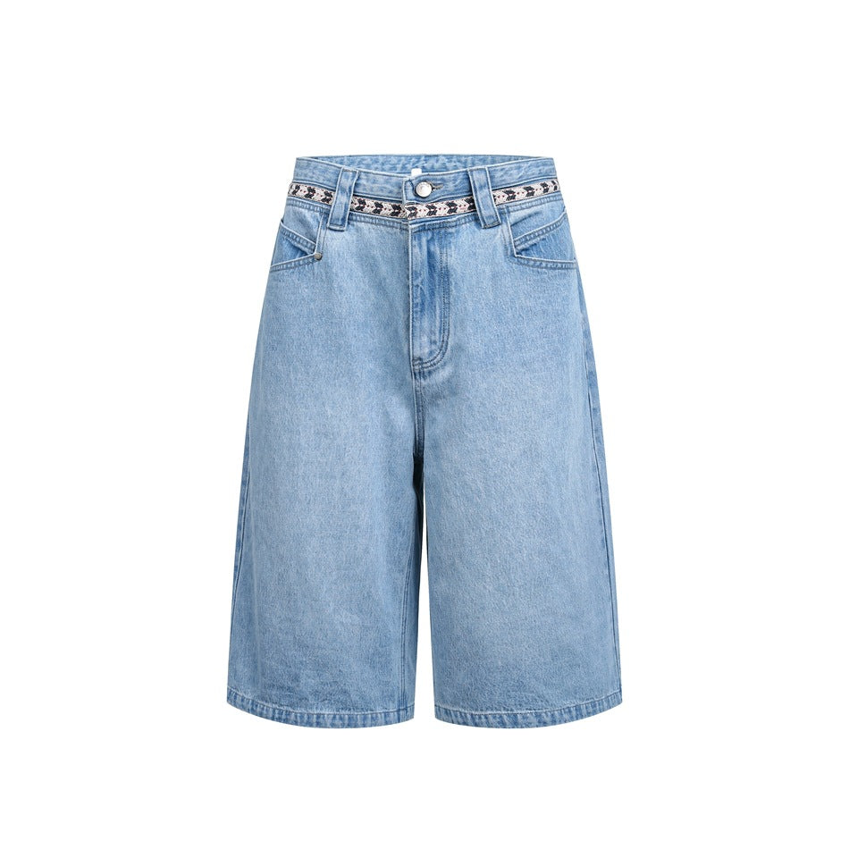 Light-wash blue denim knee-length shorts with woven tape trim at the waistband, front flat view on white