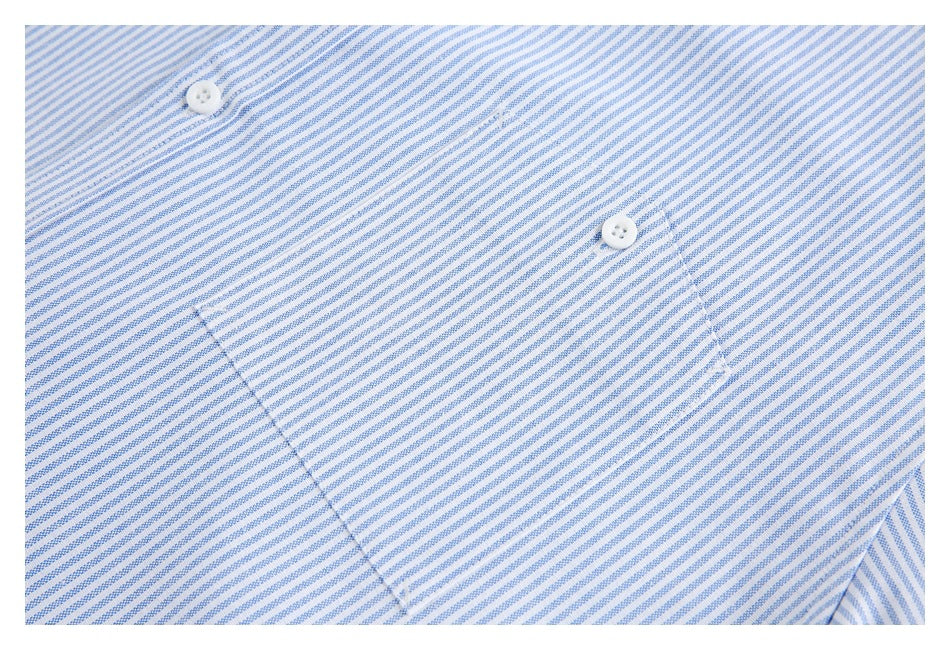 Close-up of a blue-and-white striped shirt pocket area with two white buttons.