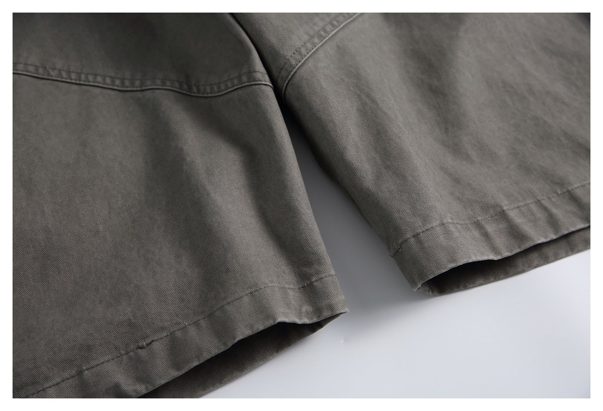 Close-up of two finished hems on charcoal-gray trousers, showing the stitching and fabric.