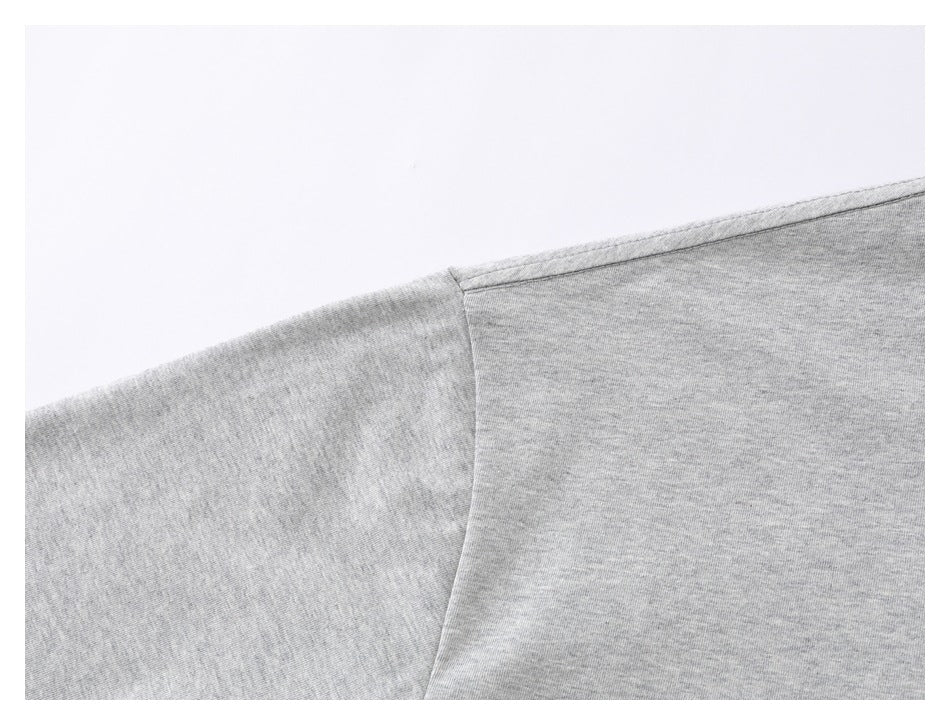 Close-up of the shoulder seam on a heather gray T-shirt.