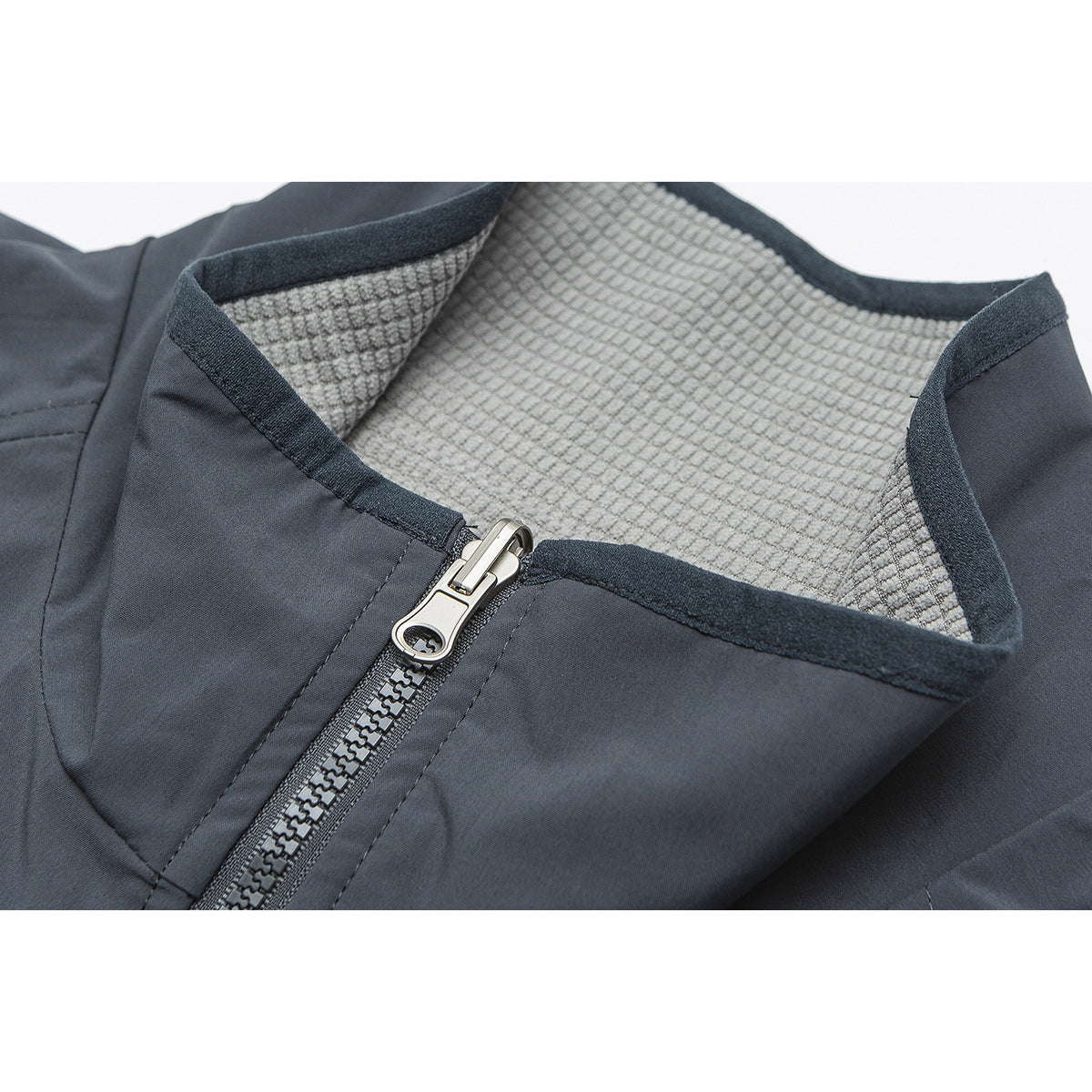 Close-up of a dark gray jacket collar, showing the textured light gray lining and metal zipper.