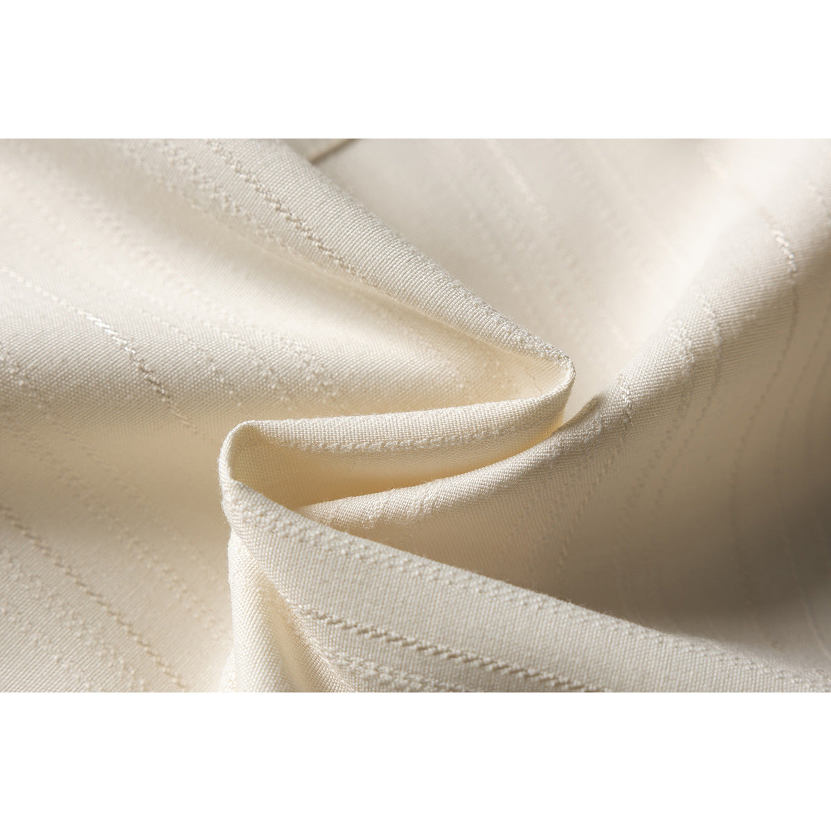 Close-up of cream fabric with subtle vertical stripes and stitched seams.