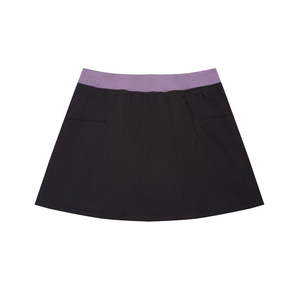 Flat-lay front view of a dark skirt with a flared hem, side pockets, and a wide ribbed lavender waistband.