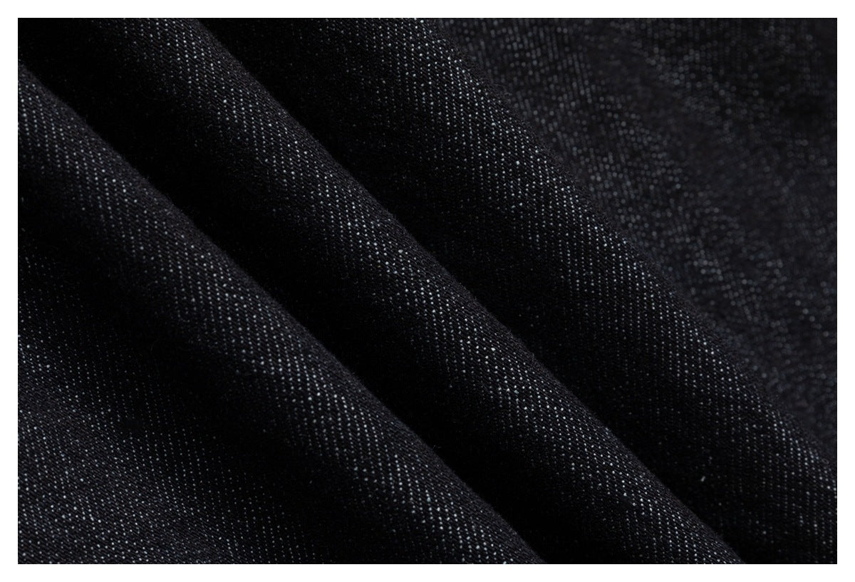 Macro view of dark denim weave and folded fabric texture.