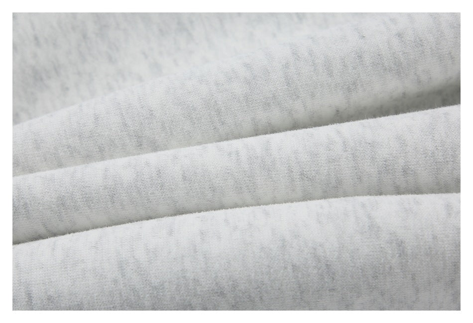 Extreme close-up showing the light gray heather sweatshirt fabric and its surface texture.