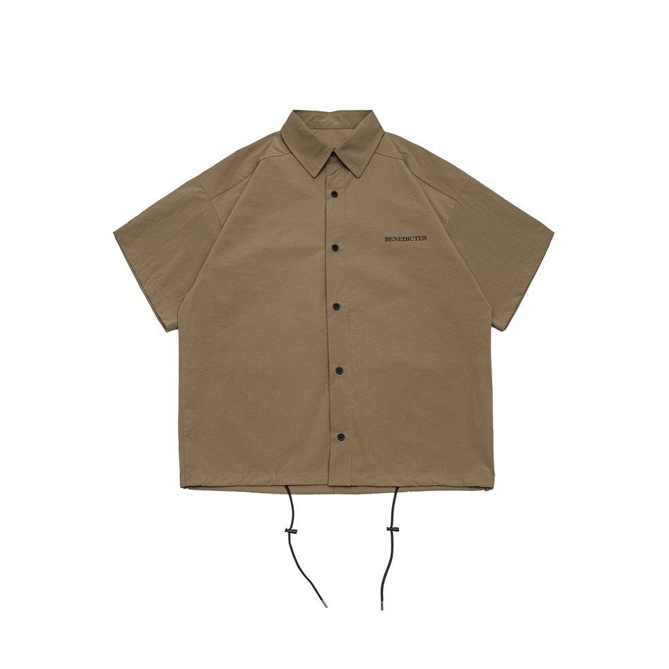 Khaki short-sleeve button-front shirt with collar, small chest lettering and drawstring hem, flat lay