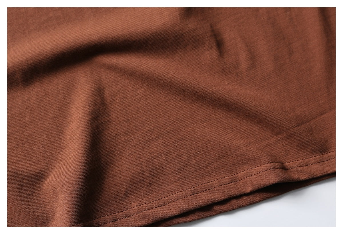 Close-up of the double-stitched hem on rust-brown garment fabric.