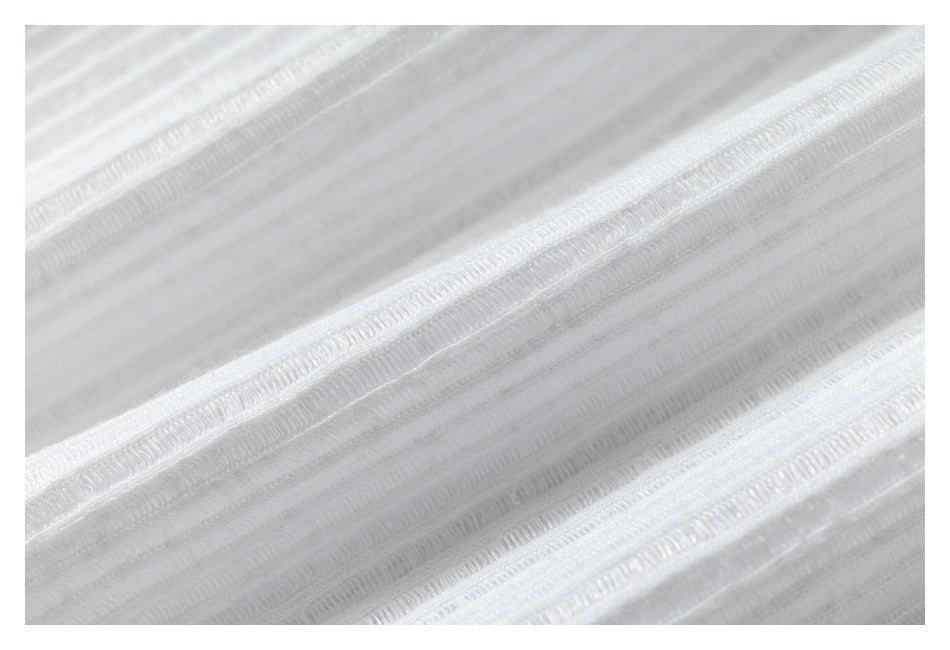 Macro view of the white garment's raised ribbed fabric texture.