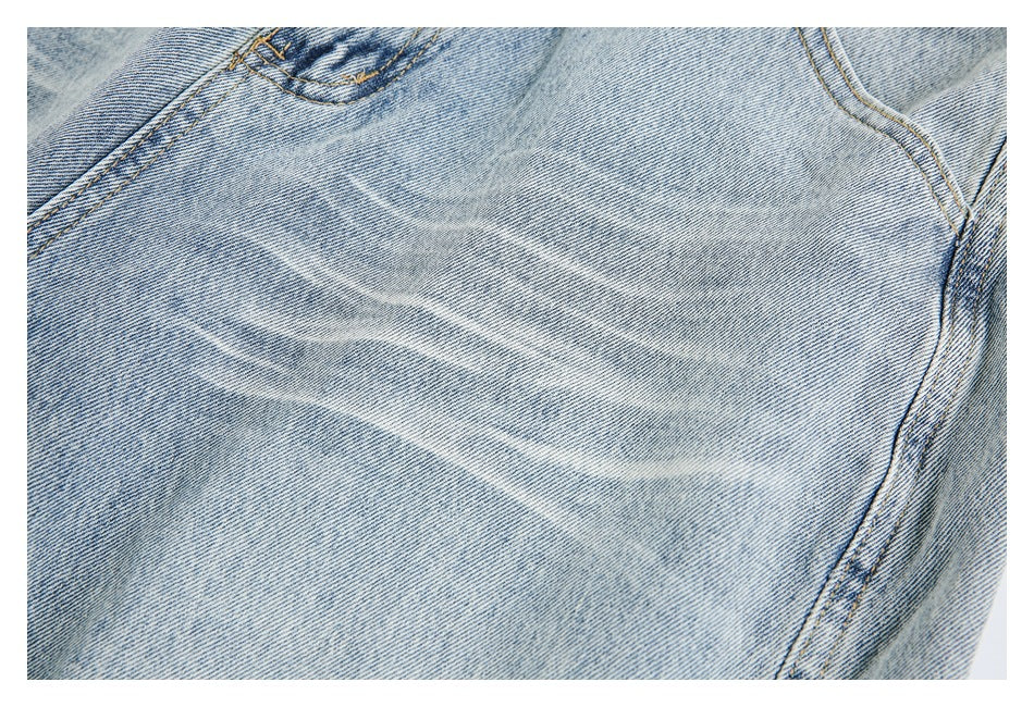 Close-up of pale whiskering and faded wash across the light-blue denim.