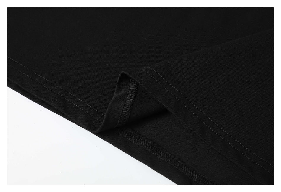 Close-up of a black T-shirt hem showing double stitching and overlocked seam finish.