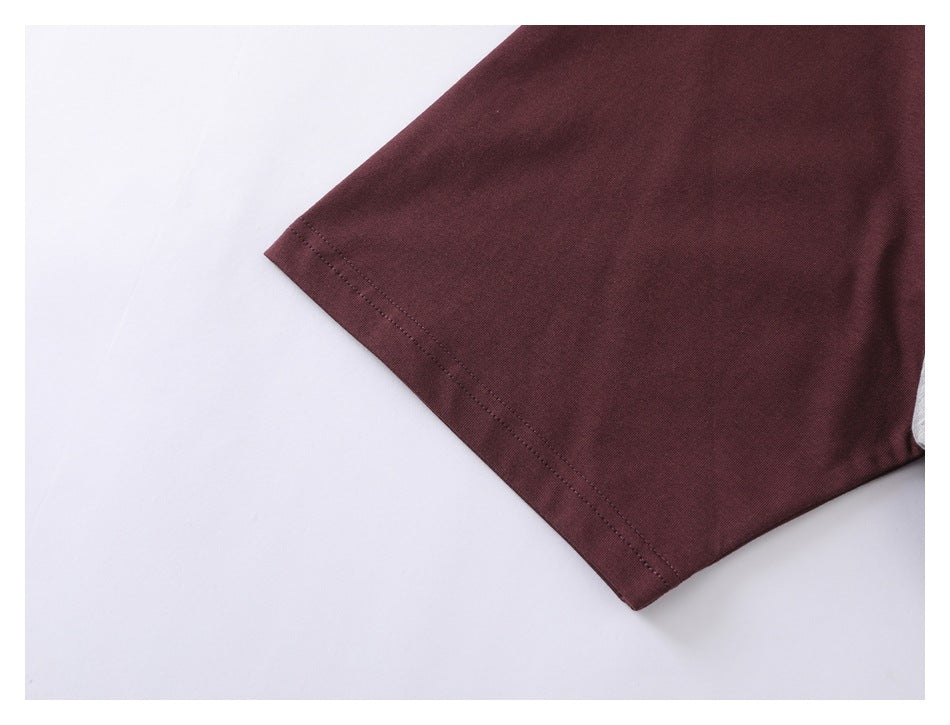 Close-up of a burgundy short sleeve showing its double-stitched hem.