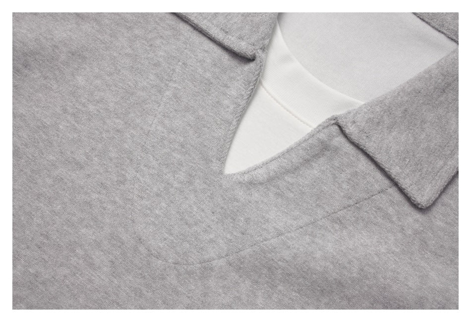 Close-up of a light gray top's pointed collar, V-neckline, and white inner layer.