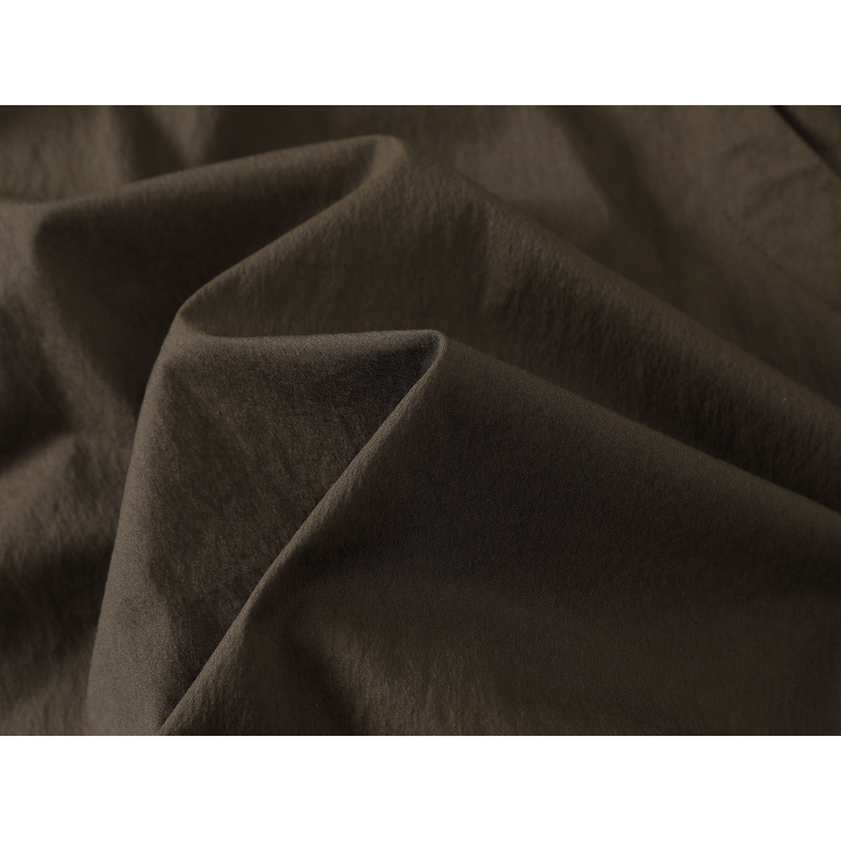 Close-up of dark olive-brown fabric arranged in soft folds.