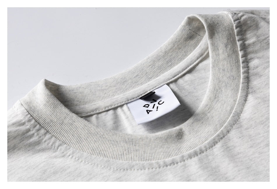 Close-up of the ribbed collar and sewn-in label on a light heather-gray T-shirt.