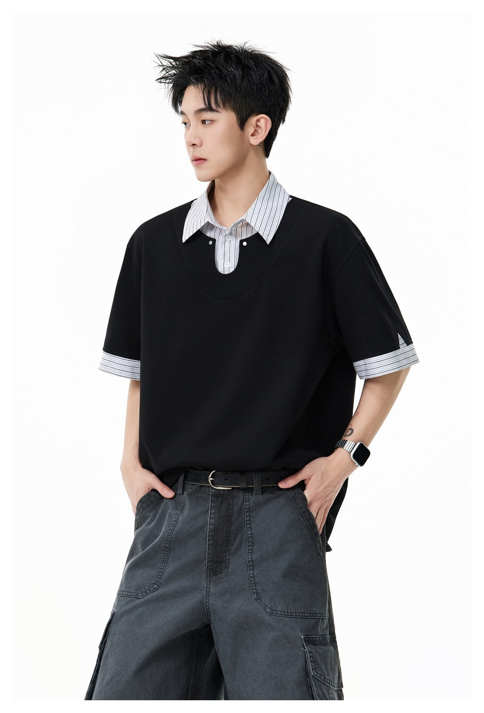 Model in a black oversized short-sleeve top with a striped collar and cuffs, shown at a slight angle.