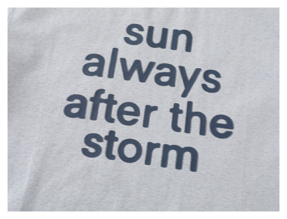 Close-up of the light gray T-shirt's dark blue printed phrase, “sun always after the storm.”