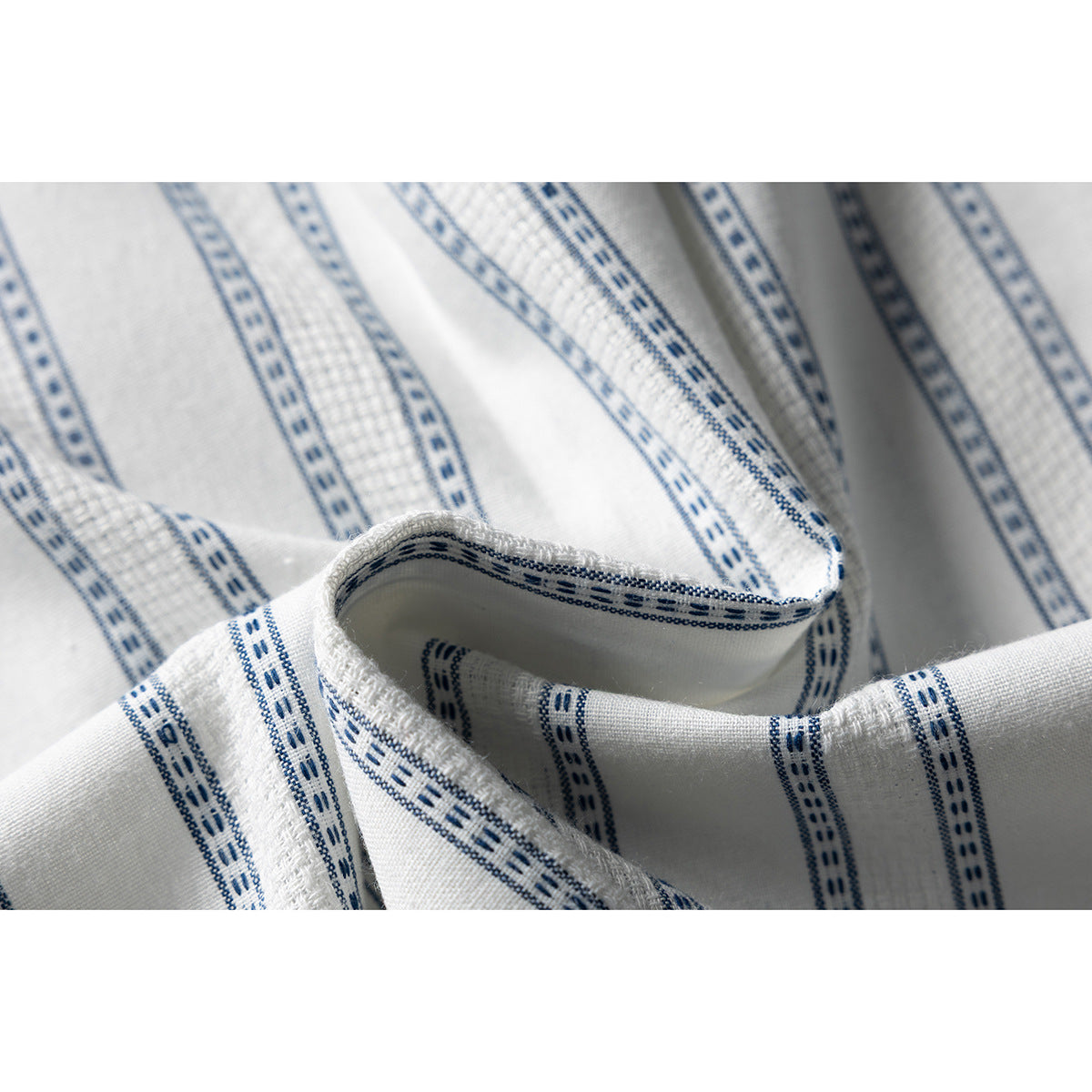 Close-up of the white shirt fabric, showing narrow blue patterned stripes and textured woven sections.