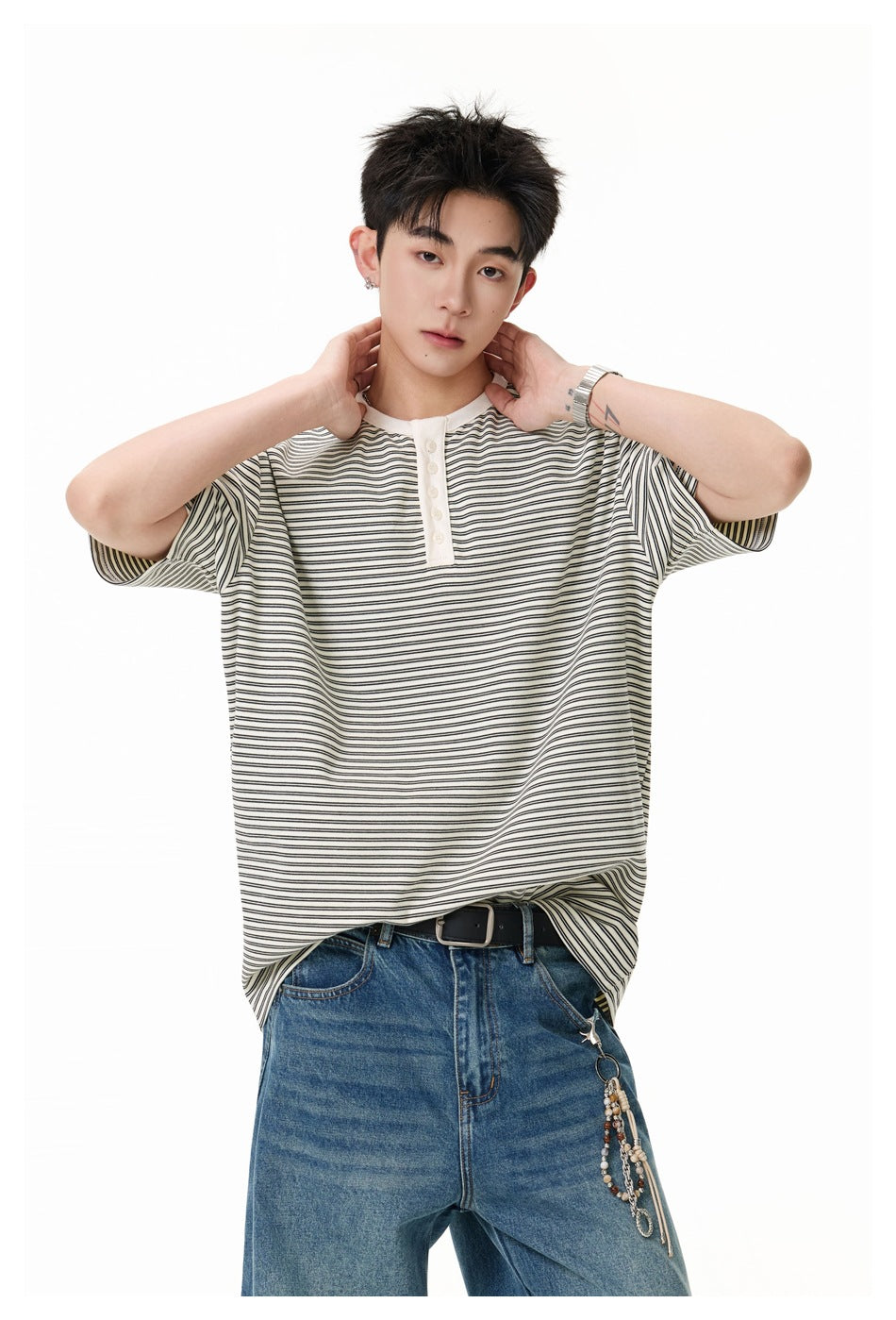 Close view of a model in an ivory and black striped henley with a light button placket.
