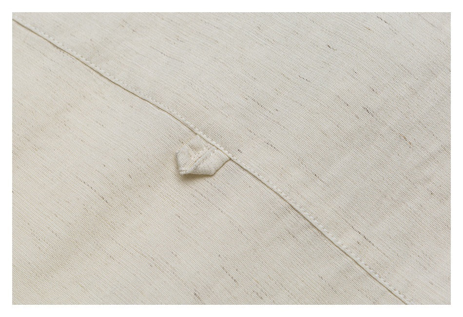Close-up of an off-white fabric loop beside a stitched seam on the shirt.