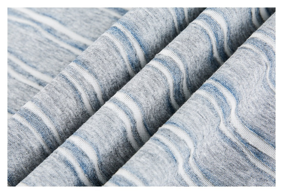Close-up of gray, blue, and white striped knit fabric draped in soft folds.