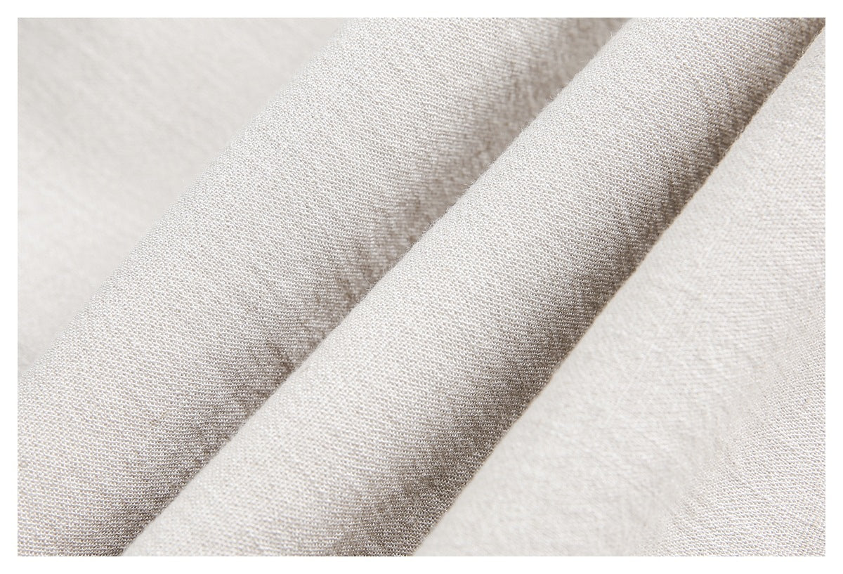Macro close-up of the fine woven surface of light beige trouser fabric.