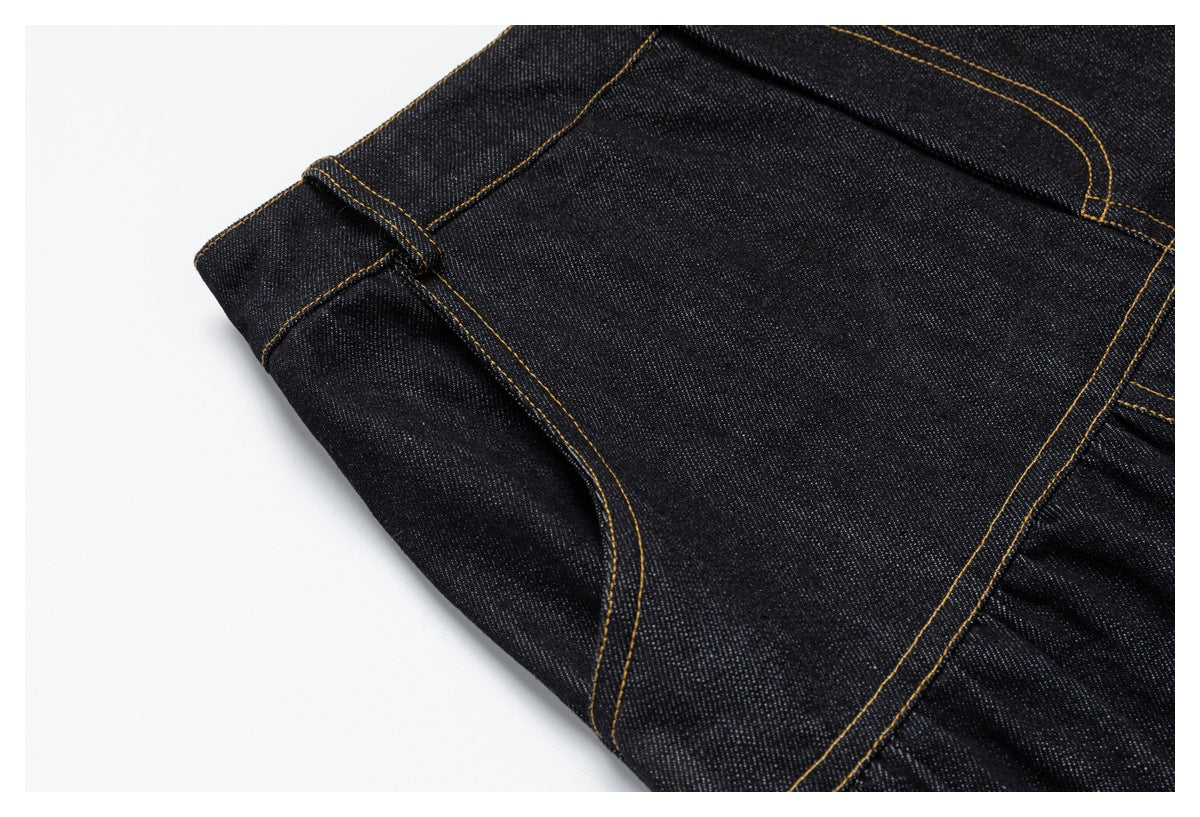 Close-up of dark denim pocket and seam construction with contrasting golden stitching.